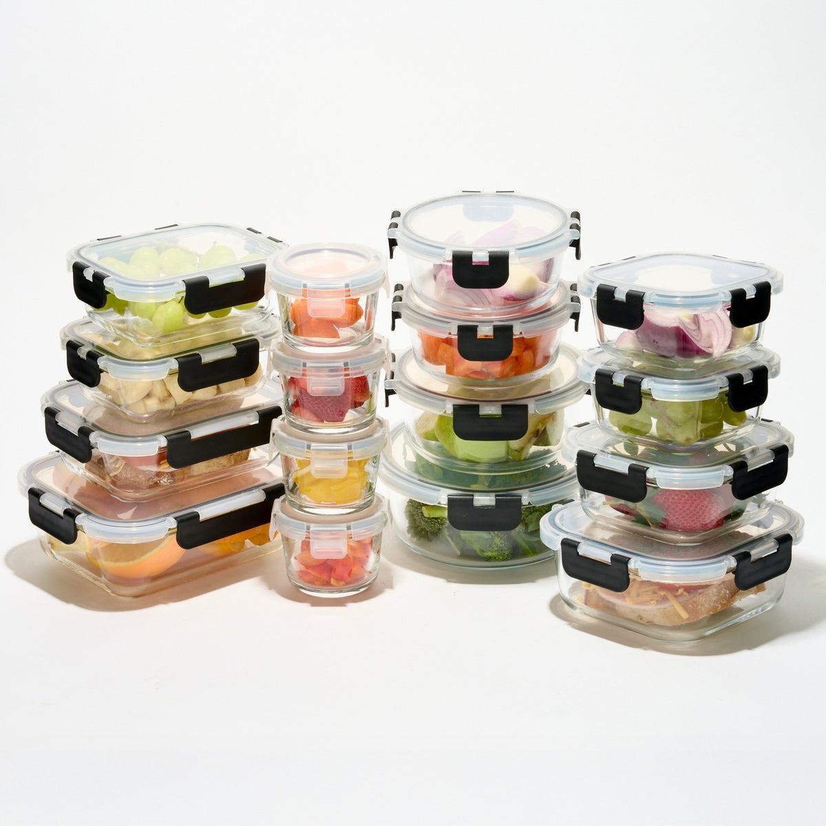 The full Storinity 32-Piece Glass Storage Container set filled with fruit, vegetables and a sandwich