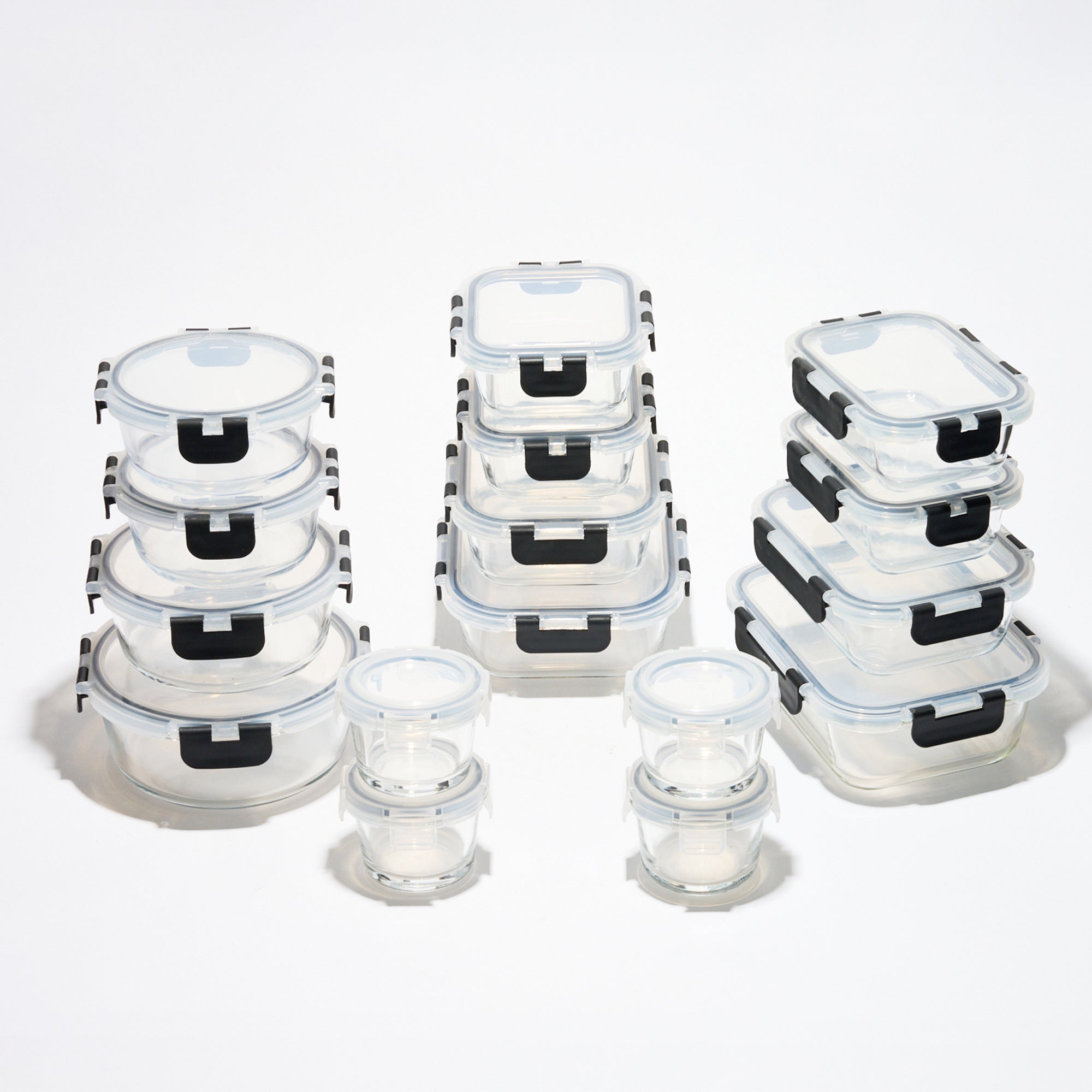 The full Storinity 32-Piece Glass Storage Container set, empty, grouped by round, square and rectangular shapes