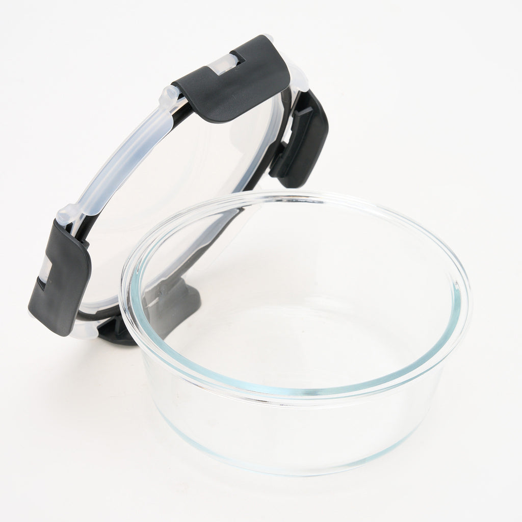 Empty round Storinity glass container with the lid propped open, showing the airtight silicone seal