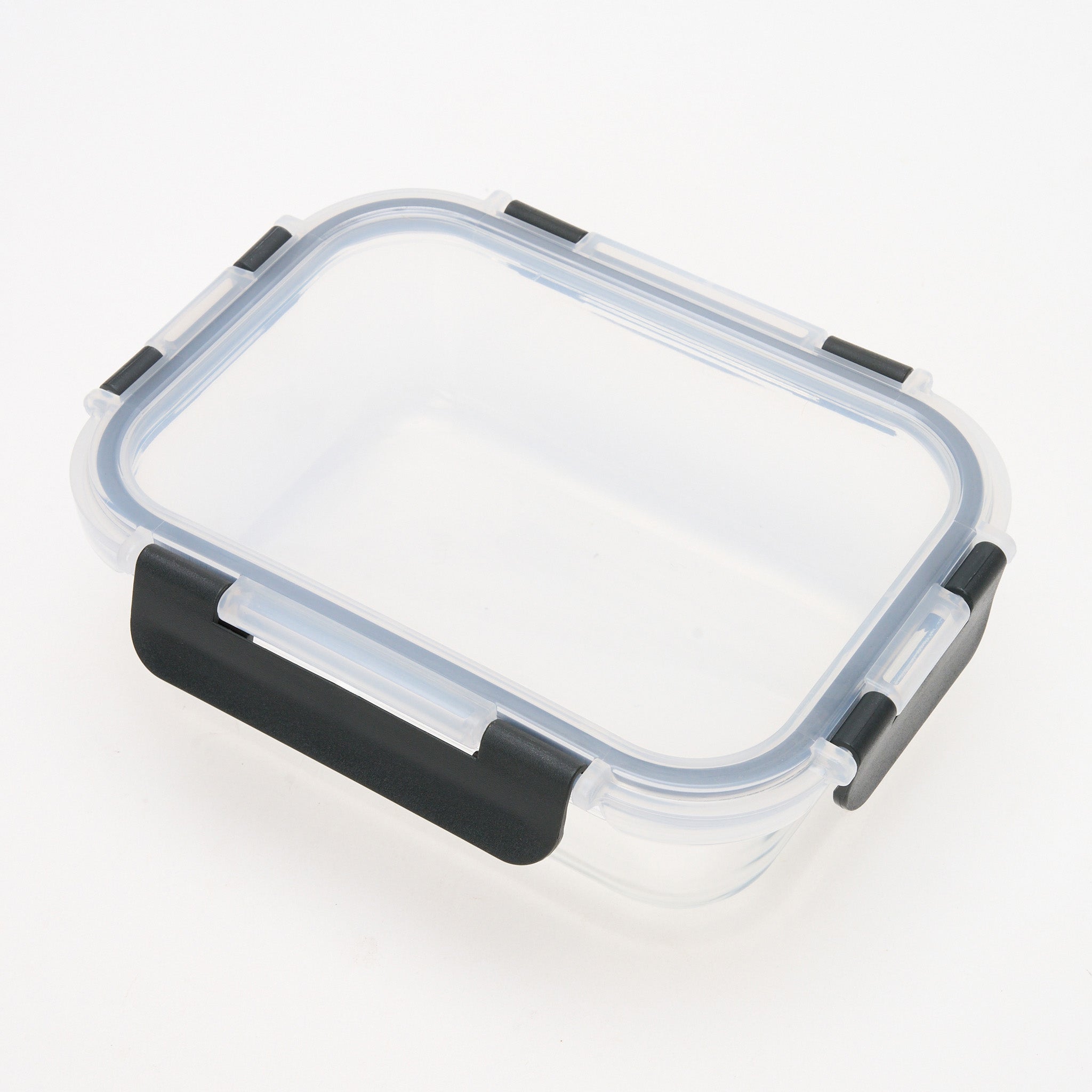 Empty rectangular Storinity glass storage container with locking lid, viewed from above at an angle