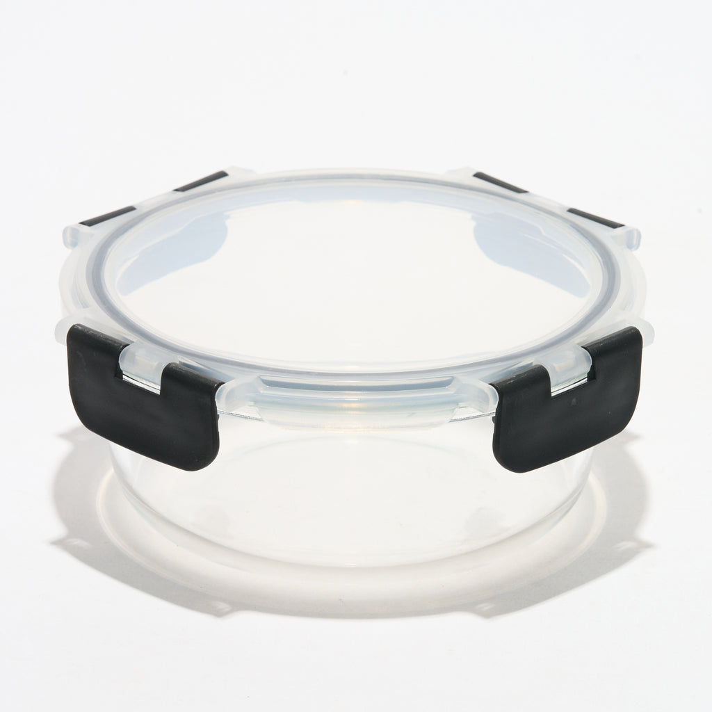 Empty round Storinity glass storage container with locking lid closed, angled view