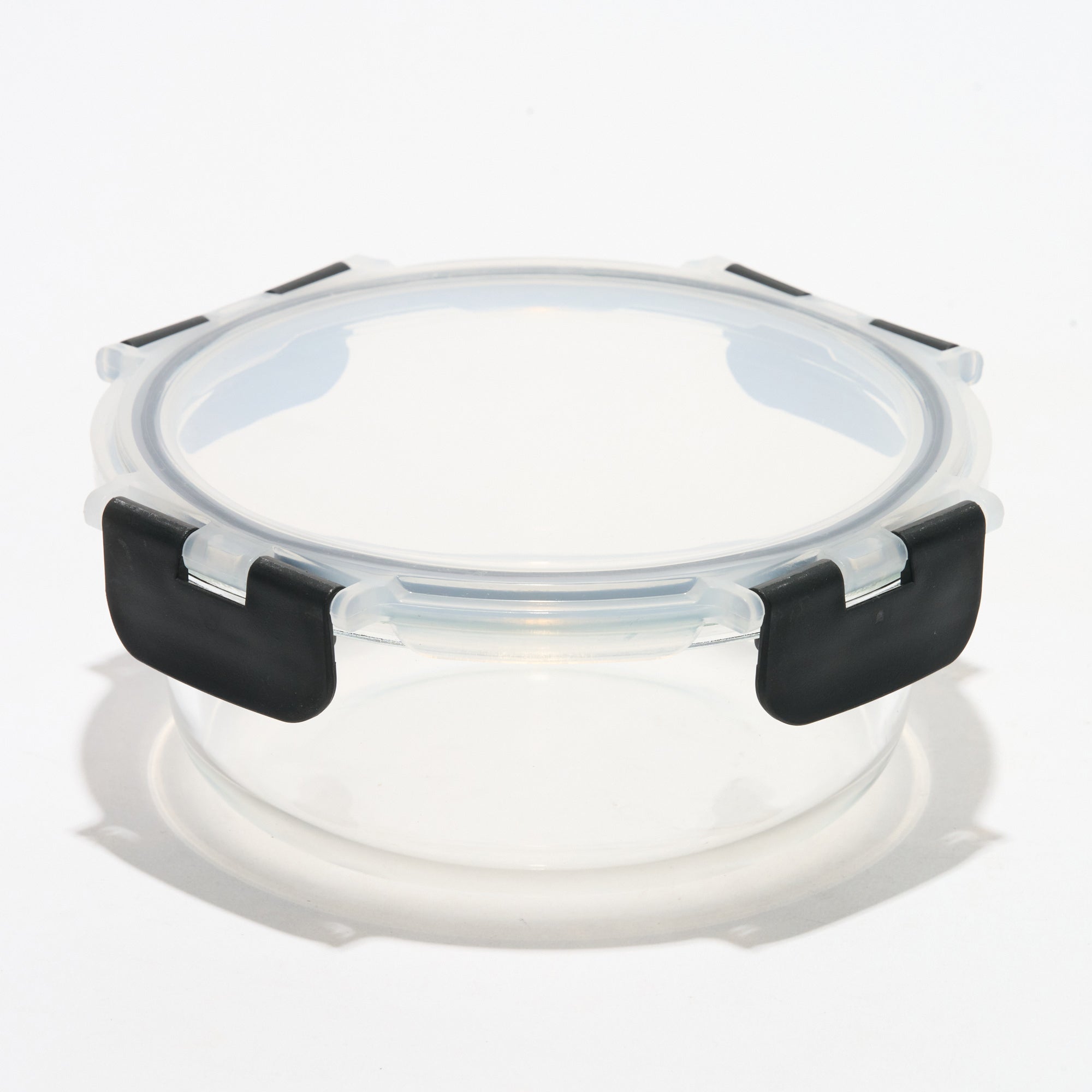 Empty round Storinity glass storage container with locking lid closed, angled view