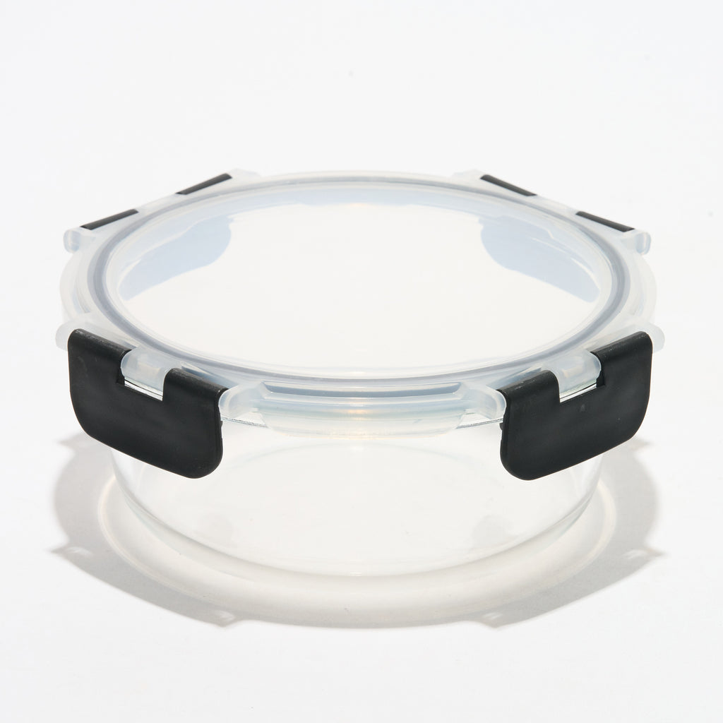 Empty round Storinity glass storage container with locking lid closed, angled view