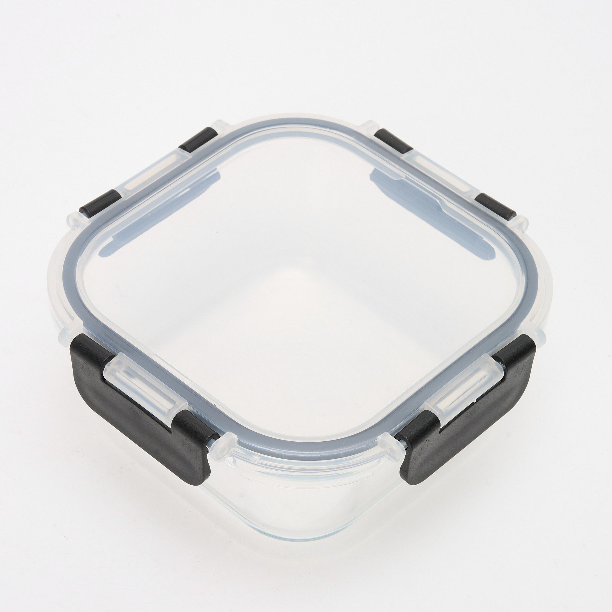 Overhead view of an empty square Storinity glass container with black locking lid, showing all four clips