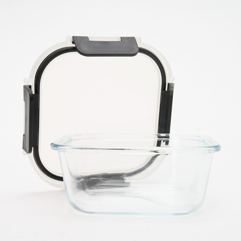 Empty square Storinity glass container with the lid propped up behind it