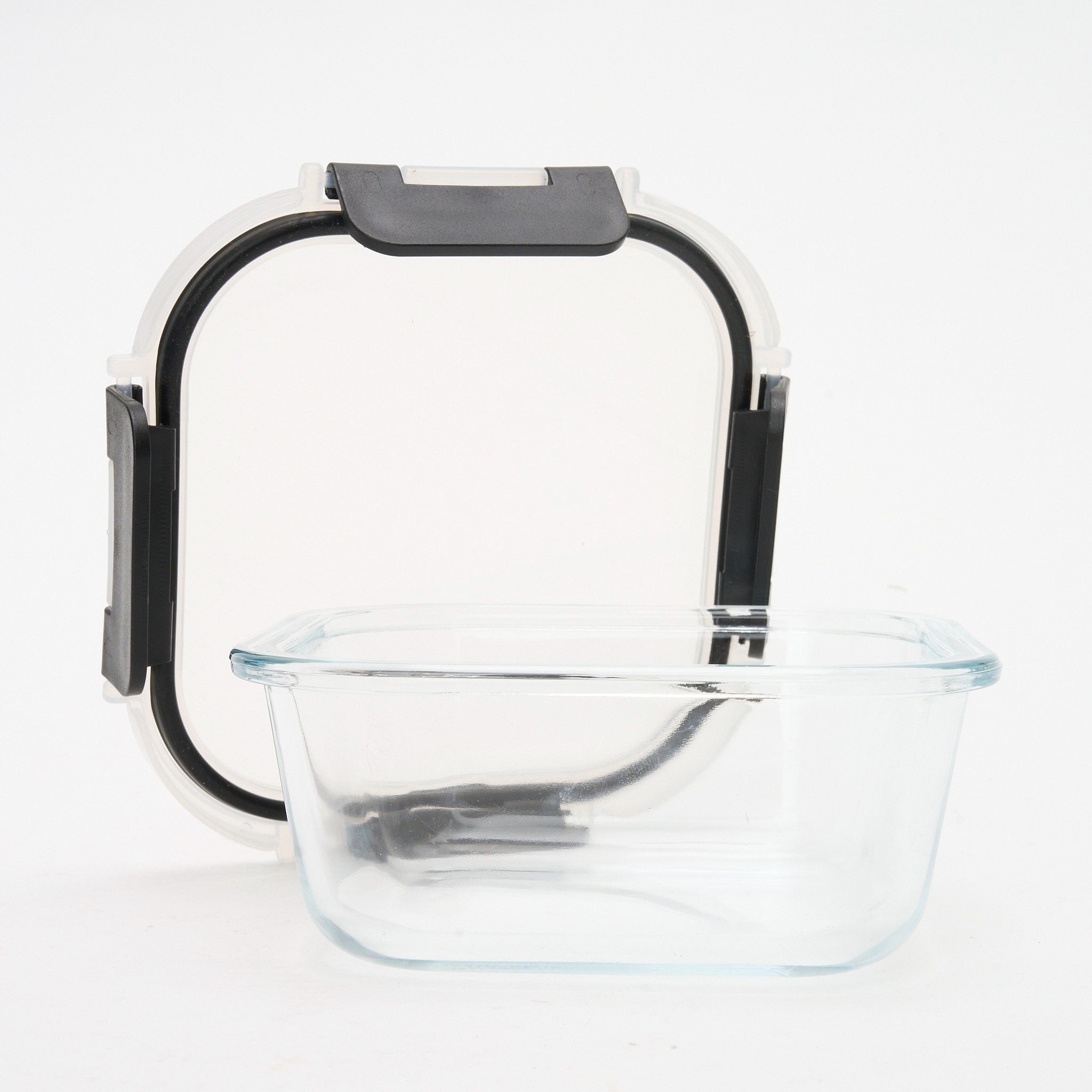 Empty square Storinity glass container with the lid propped up behind it