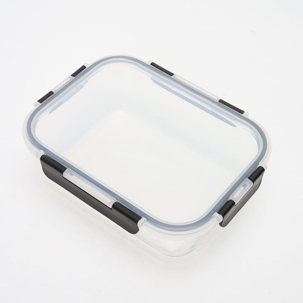 Empty rectangular Storinity glass container with black locking lid closed, angled overhead view