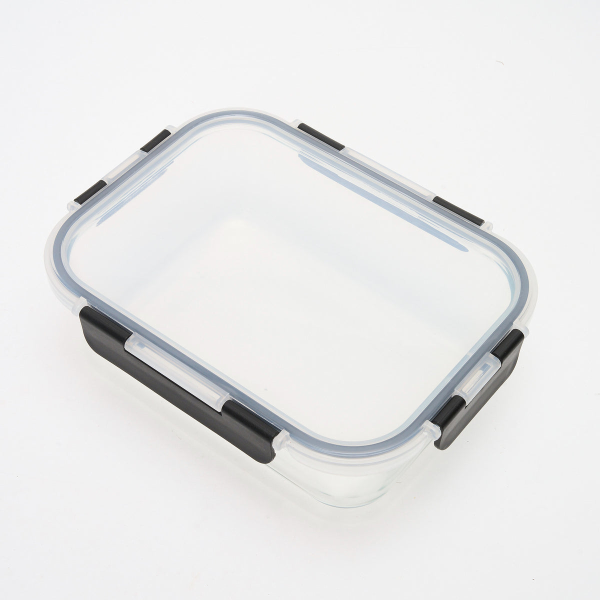 Empty rectangular Storinity glass container with black locking lid closed, angled overhead view