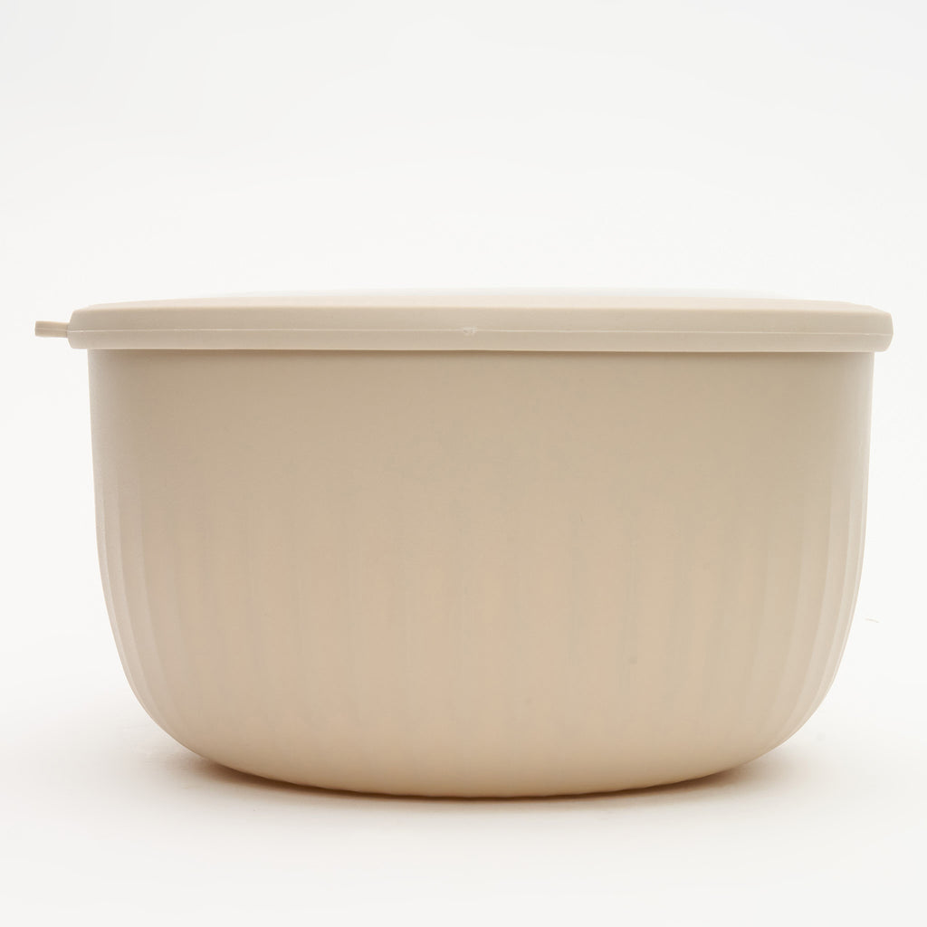 The largest Storinity nesting bowl, empty, with its lid on, cream colour, side view