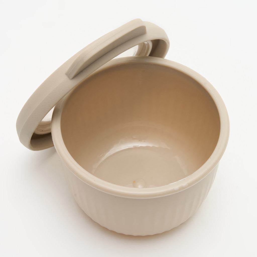 The smallest Storinity nesting bowl, empty, with the lid propped open, overhead angle