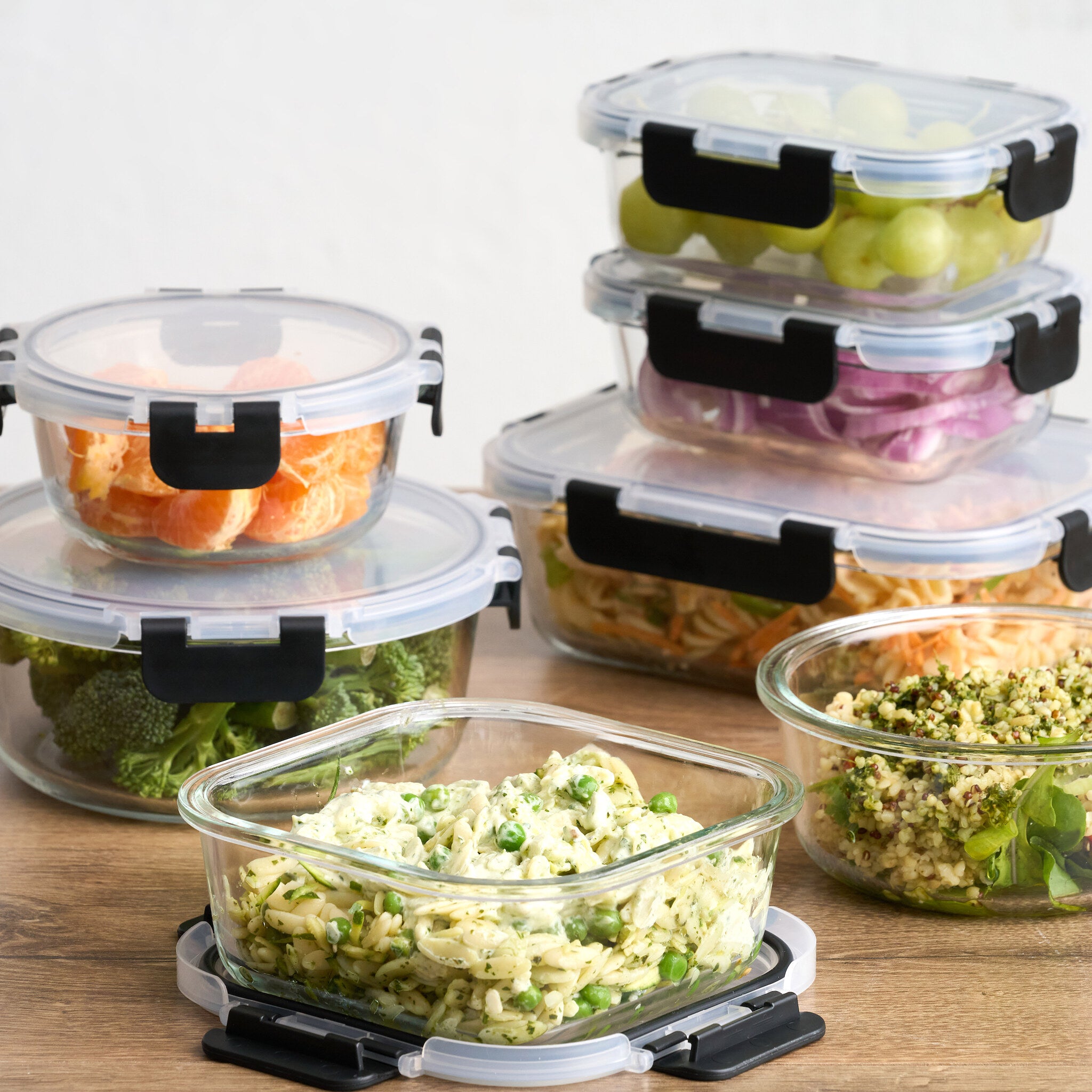 Glass storage containers with meal prep salads and fruit, close up