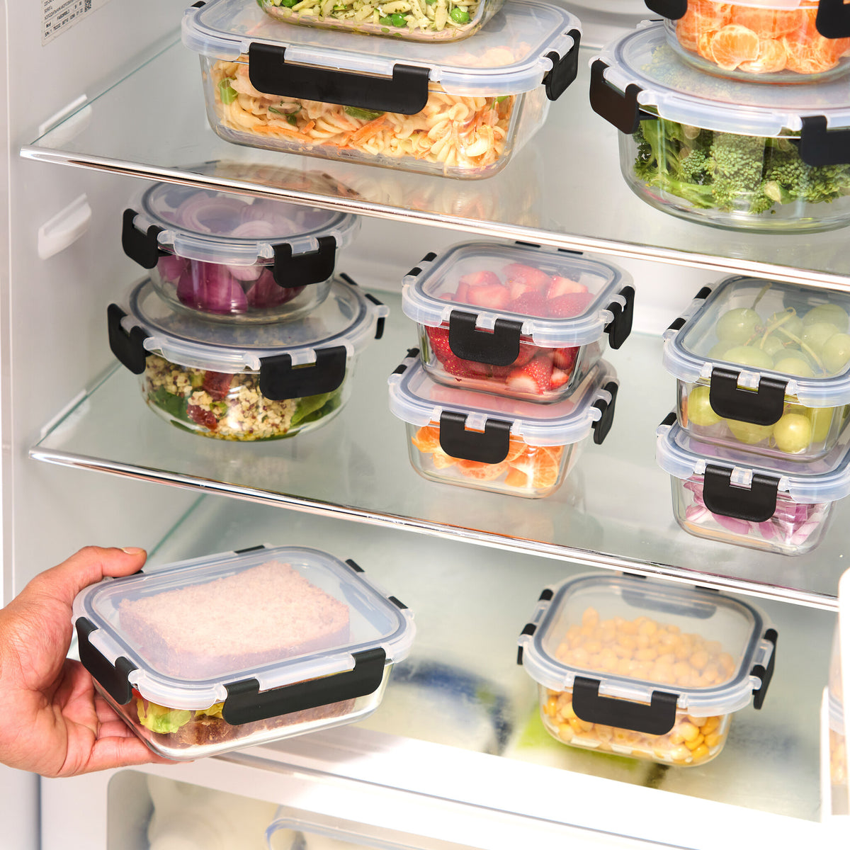 Glass storage containers stacked on fridge shelves saving space