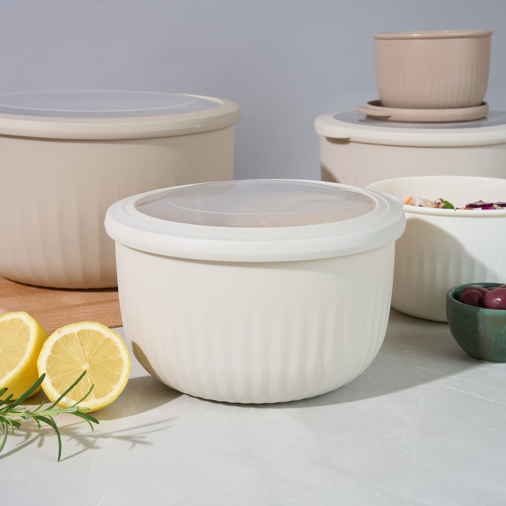 Storinity nesting bowls with lids on, styled with lemon, olives and coleslaw on a grey countertop