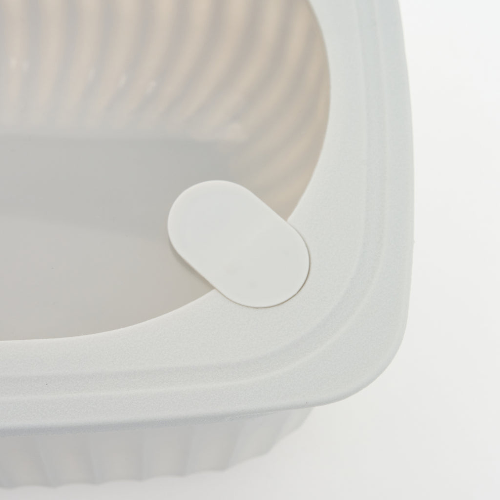 Close-up of the oval vent button on the corner of a Storinity rectangular bowl's lid